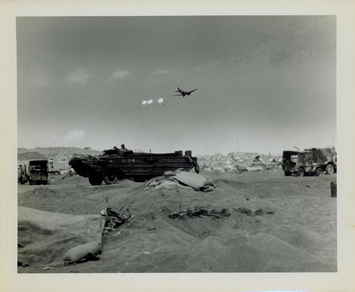 Photograph, Supply plane parachuting supplies over the beach at Iwo Jima