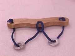 Puzzle Or Toy With Wooden Grip, String And Metal Discs